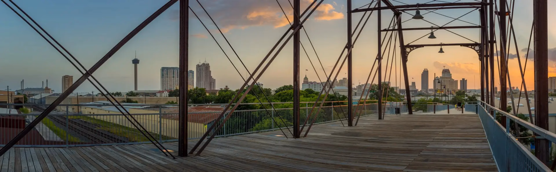 Historic iron bridge overlooking the San Antonio skyline at sunset