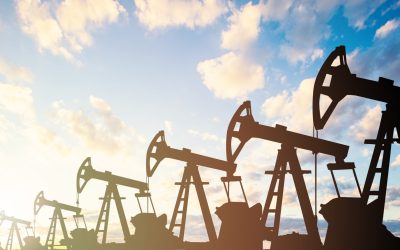 Oil pump jack. Oil industry equipment silhouette against blue sky clouds background